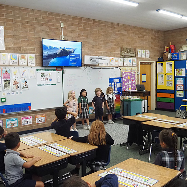 Four students singing in front of a classroom