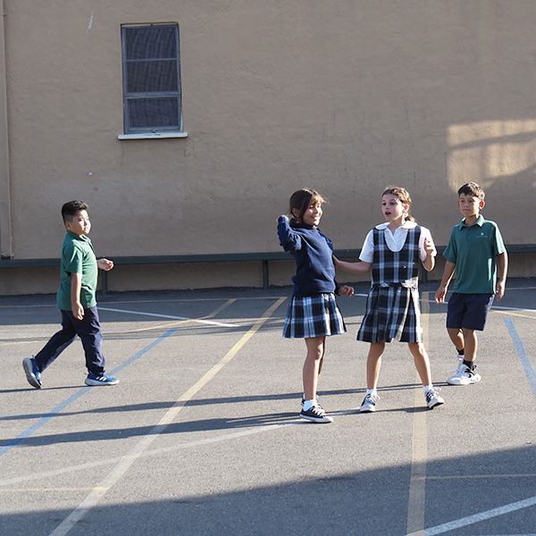 Four students in gym class stand in the outfield